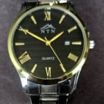 Quartz watch with black dial and gold accents, featuring date display and stainless steel strap.