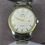 Men's quartz watch with white dial, gold accents, and stainless steel strap. Features date display a.